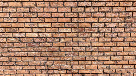 Front-view photography of red-brown not plastered weathered solid brick wall with traces of dirt, grunge, uneven color, rugged surface peeling. Abstract copy space seamless background texture.の写真素材
