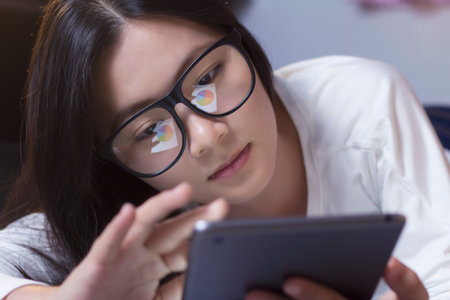 Woman using a tablet at bedroomの写真素材