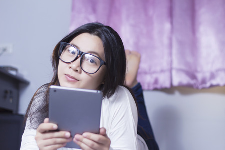 Woman using a tablet at bedroomの写真素材