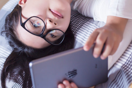 Woman using a tablet at bedroomの写真素材