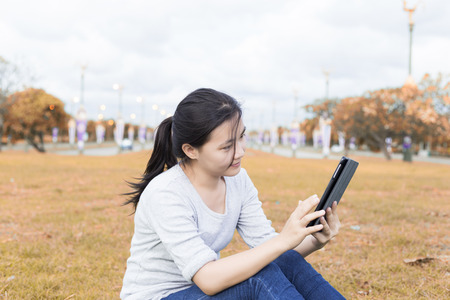 Woman use tablet in parkの写真素材