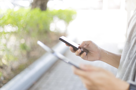 Man hold mobile smart phone and tabletの写真素材