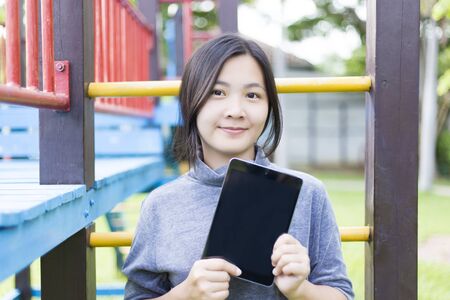 Woman Use Tablet for Relaxation at Playgroundの写真素材