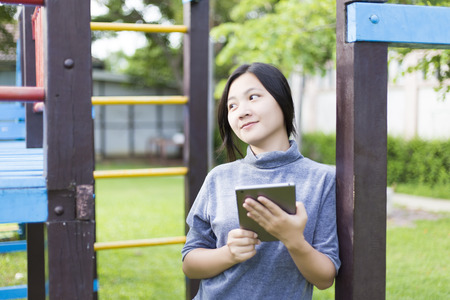 Woman Use Tablet for Relaxation at Playgroundの写真素材