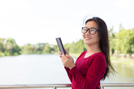 Woman Use Tablet for Relaxation on the Bridge