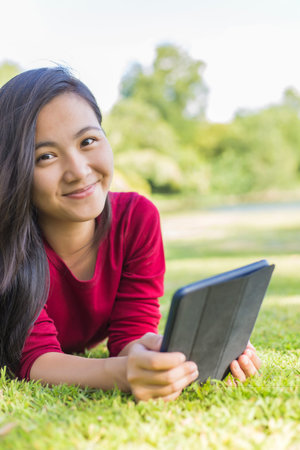 Woman Use Tablet for Relaxation at Parkの写真素材