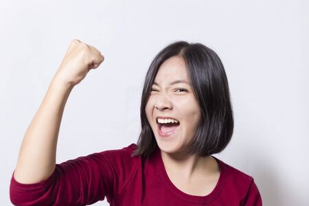 Woman gesturing victory against a white backgroundの写真素材