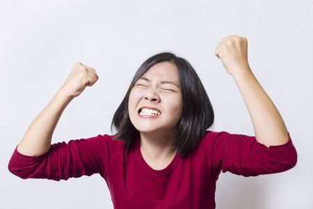 Woman gesturing victory against a white backgroundの写真素材