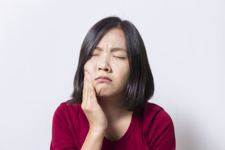 Toothache. Woman's face isolated white backgroundの写真素材
