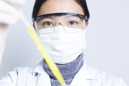 Woman Sciencetist: Researcher Holding at a Liquid Solution on Isolated Backgroundの写真素材