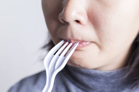 Her Mouth and Plastic Forkの写真素材