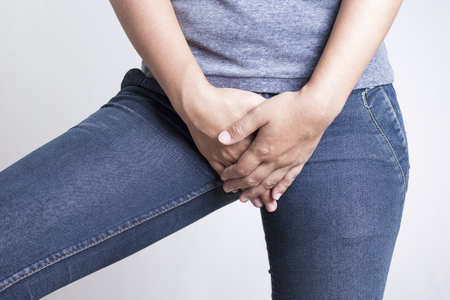 Woman with Hands Holding her Crotch Isolated in a White Backgroundの写真素材