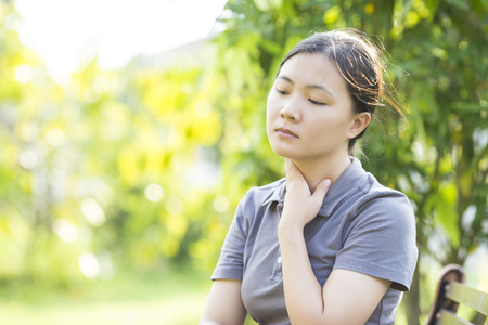 Woman has Sore Throat at Parkの写真素材