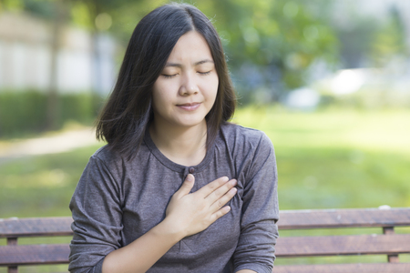 Woman has Chest Pain at Parkの写真素材