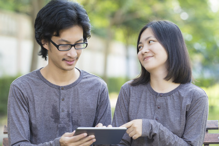 Couple Use Tablet at Parkの写真素材