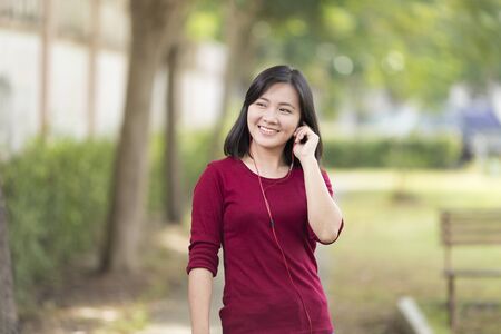 Woman Listening Music for Relaxation at Parkの写真素材
