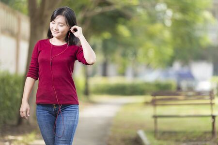 Woman Listening Music for Relaxation at Parkの写真素材