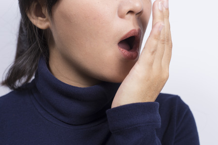 Health Care: Woman checking her breath with her handの写真素材