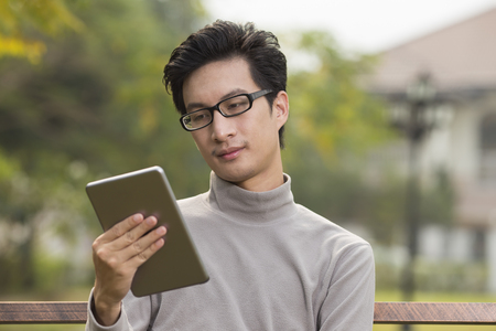 Man use tablet for relaxation at parkの写真素材