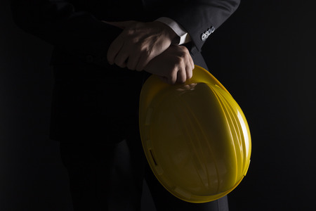 Engineer in black suit on isolated black backgroundの写真素材