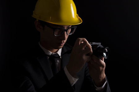 Engineer in black suit on isolated black background