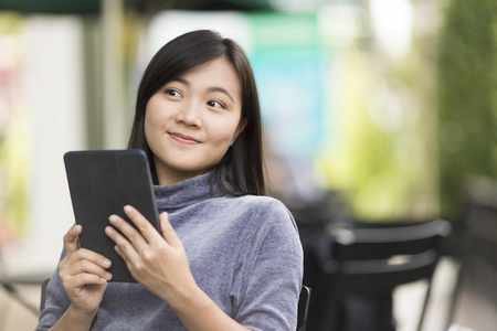 Woman using tablet in a coffee shopの写真素材