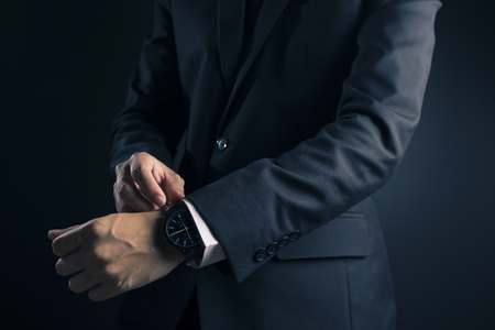 Businessman checking time from watchの写真素材