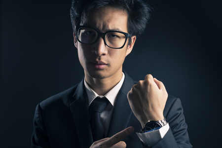 Businessman checking time from watch so seriousの写真素材
