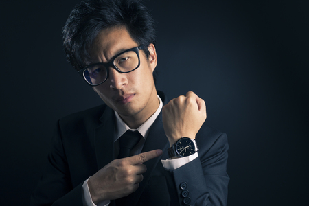 Businessman checking time from watch so seriousの写真素材