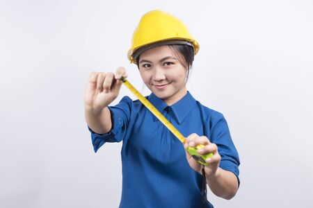 Engineer girl holding a measuring tapeの写真素材