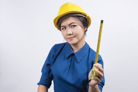 Engineer girl holding a measuring tapeの写真素材