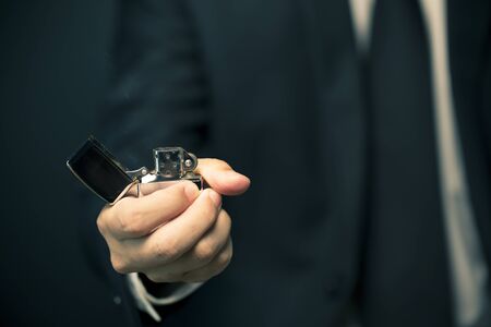 Hand igniting fire lighters on a black backgroundの写真素材