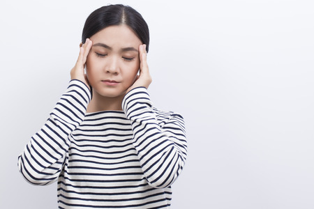 Woman has head ache isolated on white backgroundの写真素材