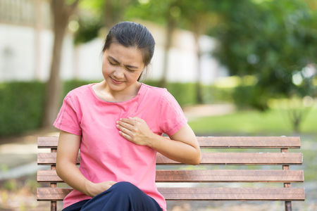 Woman has chest pain in the gardenの写真素材