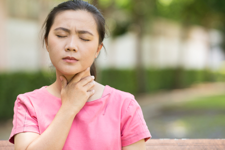 Woman has sore throat in the gardenの写真素材