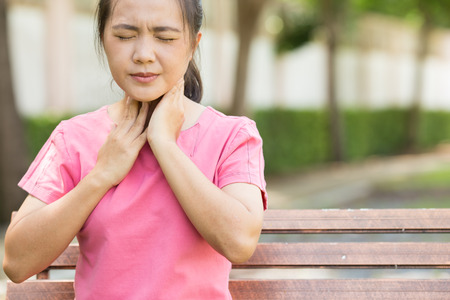 Woman has sore throat in the gardenの写真素材
