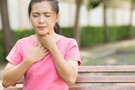 Woman has sore throat in the gardenの写真素材