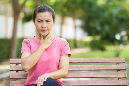 Woman has sore throat in the gardenの写真素材