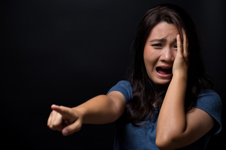 Scared woman on isolated black backgroundの写真素材