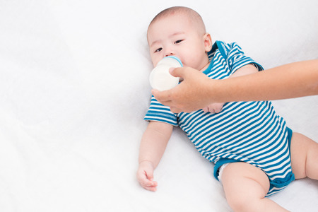 Adorable baby drinking milkの写真素材