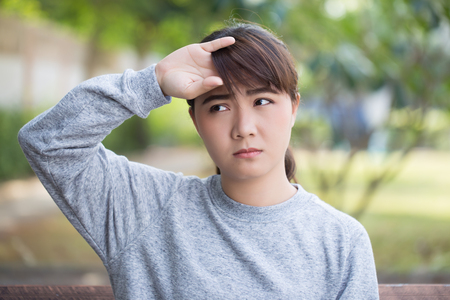 Woman has head ache at the parkの写真素材