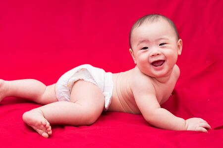 happy asian baby on red backgroundの写真素材
