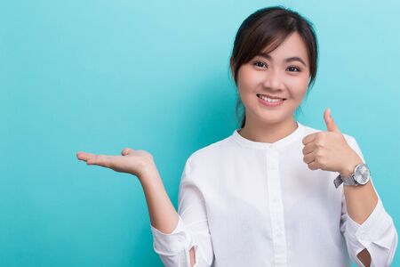 Asian woman show the copy space and show thumb upの写真素材