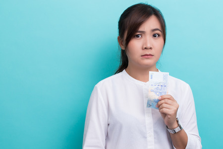 Asian woman saving banknote fifty baht has confusedの写真素材