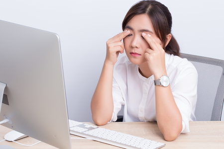 Woman has eye pain from workの写真素材
