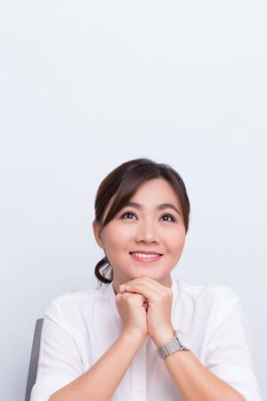 Asian woman pointing to the copy space isolated on blue backgroundの写真素材