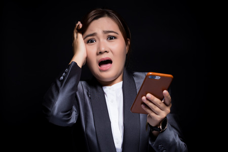 Woman look at smartphone and she shockedの写真素材