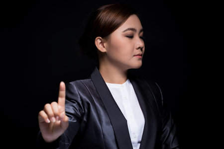 Businesswoman show finger pointing on dark background