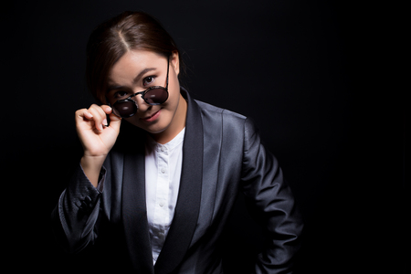 Seriously businesswoman wearing sun glasses on isolated backgroundの写真素材