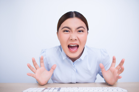 Angry woman screaming out and pulling her hairの写真素材